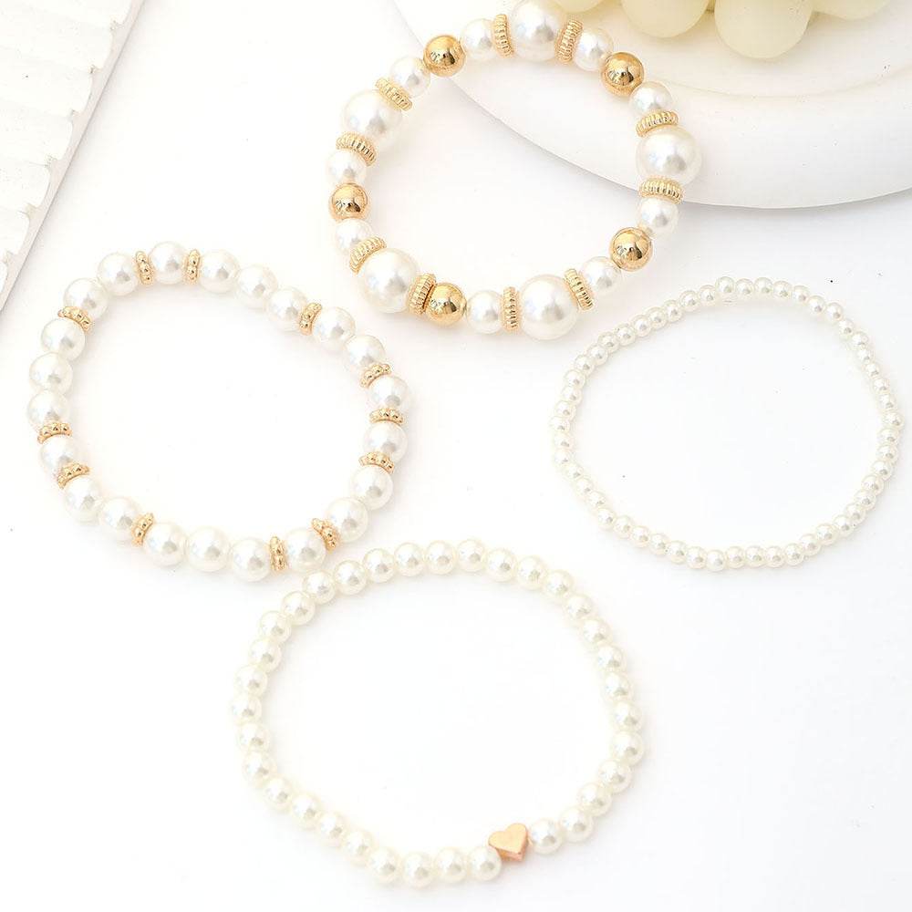 Pearl and gold beaded necklaces on a white surface