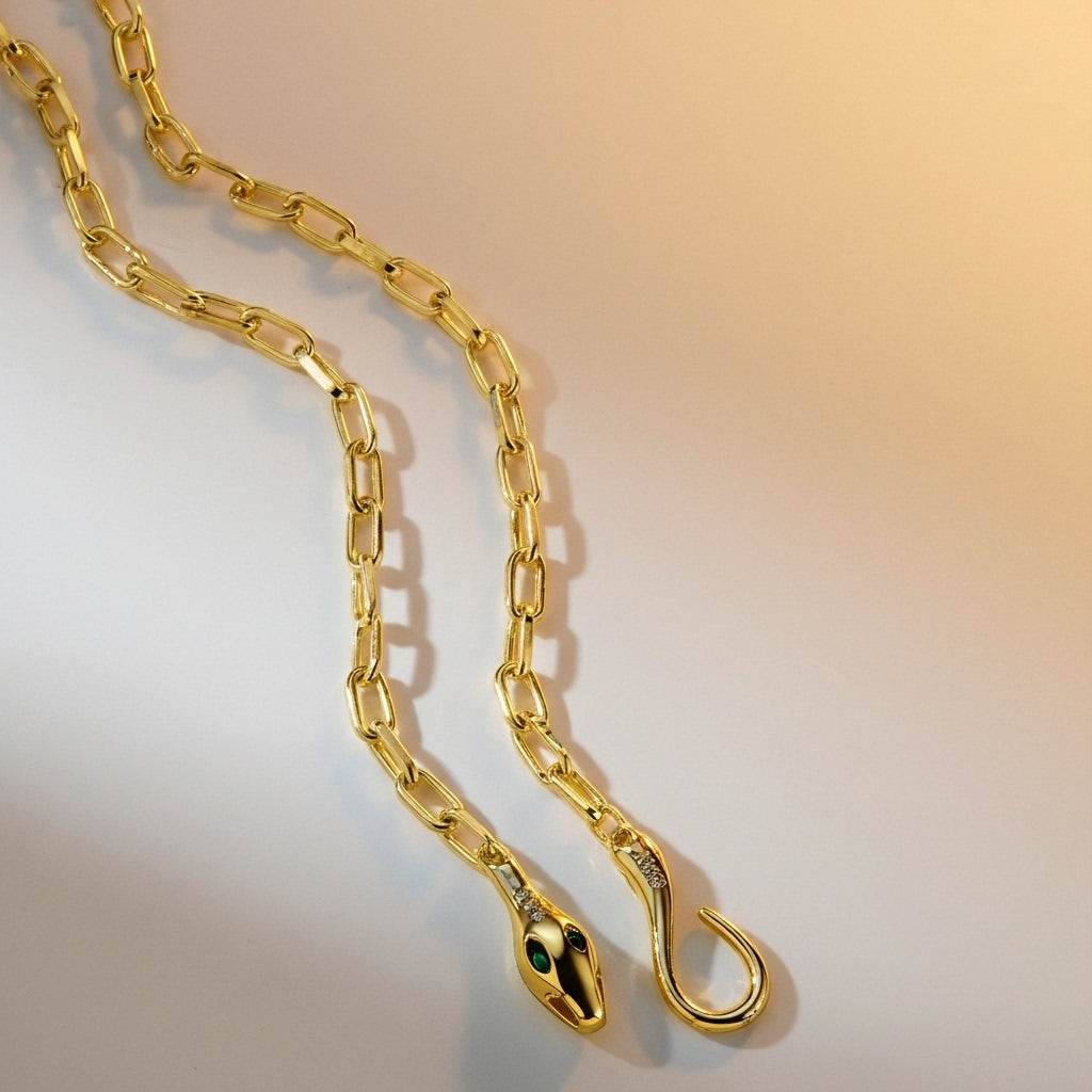 Gold chain with snake head design on a gradient background