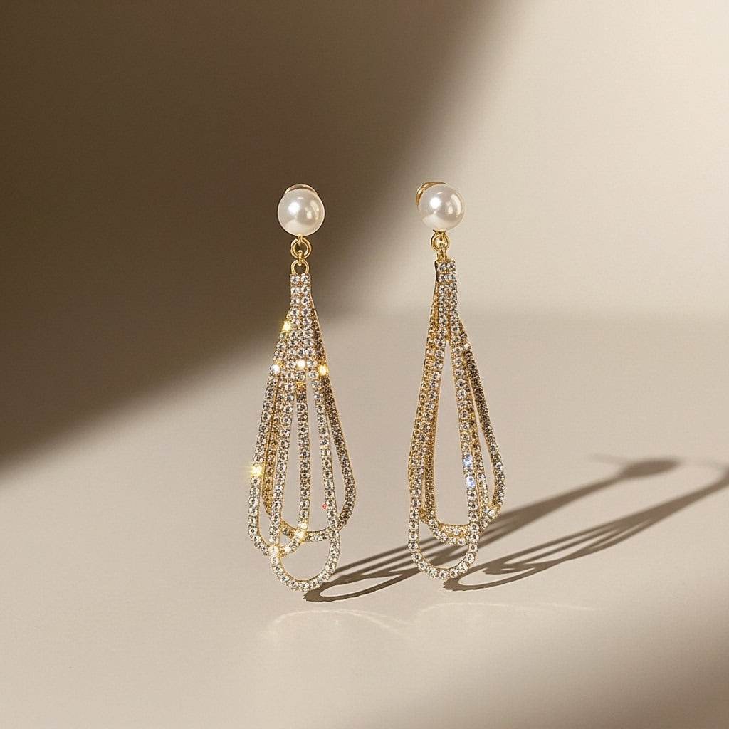 Pair of gold and pearl earrings on a beige background