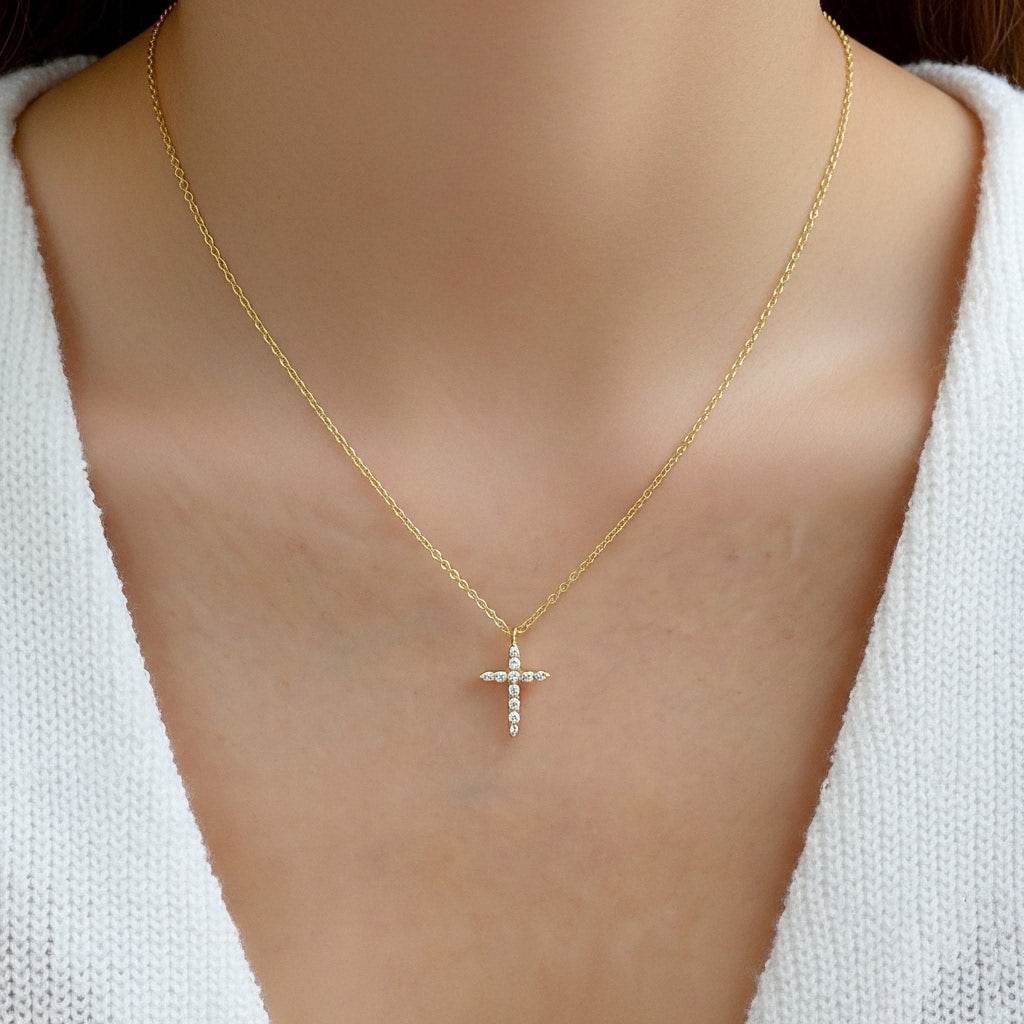 Gold necklace with a cross pendant on a mannequin
