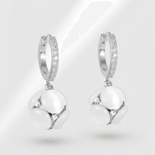 Pair of silver hoop earrings with white spherical charms on a light gray background