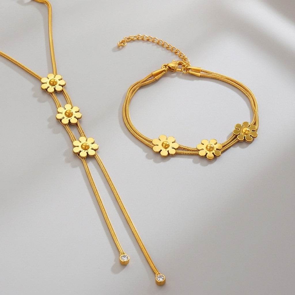 Gold necklace and bracelet set on a light gray background