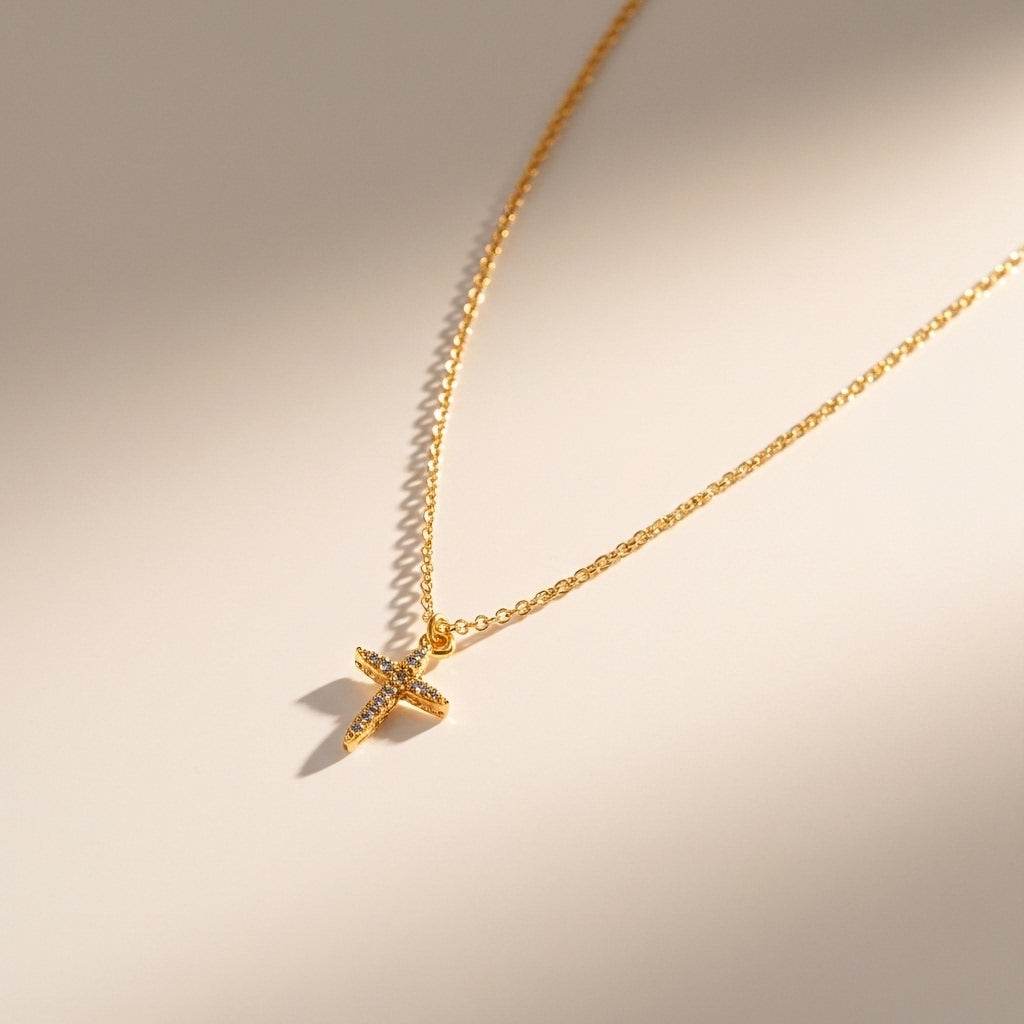Gold necklace with a cross pendant on a beige background