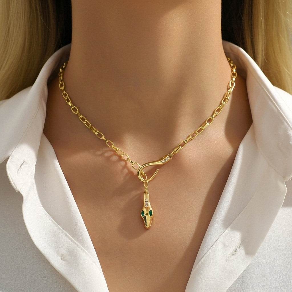 Gold necklace with a snake pendant on a mannequin wearing a white shirt.
