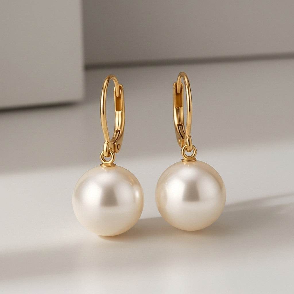 Gold hoop earrings with large pearls on a light background