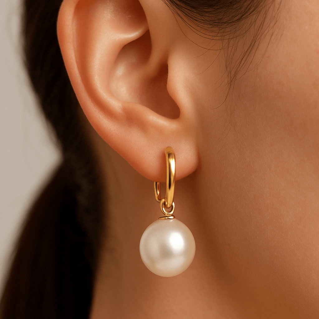 Pearl earring on a person's ear with a neutral background